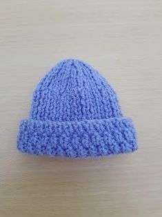 a blue knitted hat sitting on top of a wooden table