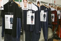 men's clothing on display in a store with price tags hanging from the racks