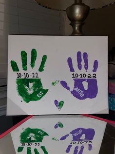 two handprints are displayed on top of each other in front of a lamp