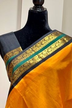 This regal korvai silk cotton saree in mustard yellow with black border and pallu is handwoven. The saree borders are adorned with traditional motifs in gold zari. The black pallu is grand with a rich gold zari work. Approximate Length 6.5 mtrs (inclusive of blouse length) Approximate weight - 1.2 lbs Approximate Height - 48 - 50" Saree comes with fall, picot and tassels done when applicable. Blouse piece is cut. Kindly Note : The colors you see on your device may vary due to the color reproduct