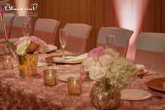 the table is set with pink and white flowers