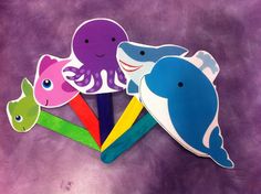 four different colored paper cut outs with an octopus, shark and dolphin on them in the middle