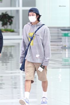 a man wearing a face mask while walking through an airport