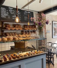 a bakery filled with lots of pastries on display next to a dining room table