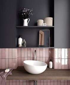 a white bowl sink sitting on top of a wooden counter next to a shelf filled with bottles