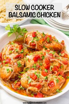 two bowls filled with chicken and vegetables on top of a white table cloth next to plates