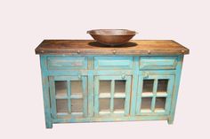 an old blue cabinet with a bowl on top