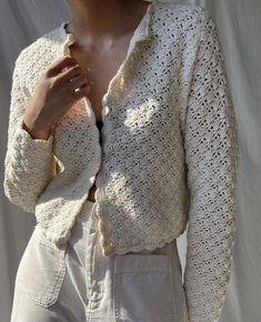 a woman wearing a white crochet jacket and pants