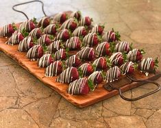 chocolate covered strawberries are arranged on a wooden platter and ready to be eaten