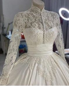 a white wedding dress with long sleeves and lace on the bouncy neckline