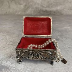 an old silver box with pearls and a necklace