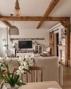 a living room filled with furniture and a flat screen tv on top of a wooden table