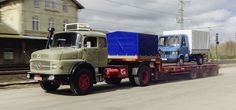 two trucks are traveling down the road together