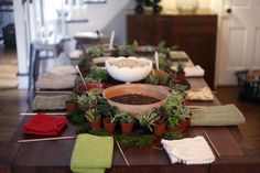 the table is set up with bowls and plants