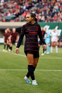 a female soccer player is walking on the field