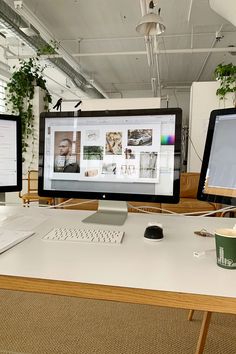 two computer monitors sitting on top of a desk next to a keyboard and monitor screen