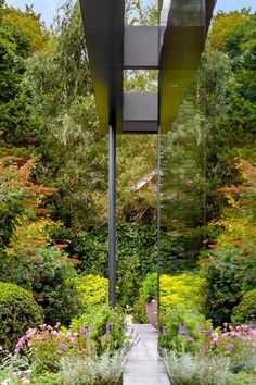 an outdoor walkway surrounded by flowers and trees