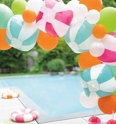 some balloons are floating in the air near a pool