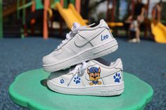 Say hello to our Paw Patrol Toddler Boy Air Force 1 Low Custom Kids Shoes! Featuring vibrant Paw Patrol designs hand-painted onto these AF1 sneakers, they're perfect for his everyday escapades. These kicks are as comfy as they are cool, ensuring he's ready for any adventure. Shop now and watch his style take flight! Hand/spray painted paw patrol boy design. Personalize with name (optional) Resistant clear coat (protected against cracks and scratches). Custom made-to-order sneaker. Brand new 100% authentic Nike AF1 Low with box! Free shipping within the US territory! Need a different color? Let us know which color you're looking for and we'll find it for you. Have an idea for your custom painted sneakers? Please send us a message here. We'll get back to you within 48hrs! Custom Baby Shoes, Sequin Sneakers, Paw Painting, Hand Spray, Custom Shoes Diy, Painted Sneakers, Wedding Sneakers, Shoes Diy, Custom Kids