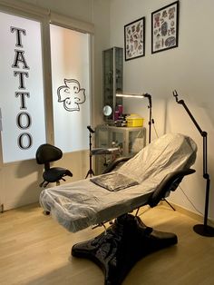 a tattoo parlor with chairs and equipment in the room, including a chair that is covered by a sheet