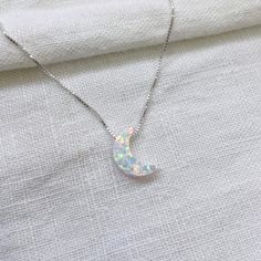 Gorgeous dainty white opal moon on a sterling silver box chain - it looks beautiful on! The moon is 'floating' on a simple and beautiful box chain. The moon is a feminine symbol, universally representing the rhythm of time as it embodies the cycle. This necklace is equally beautiful worn on its own or layered as pictured. Happily, the benefits and healing properties of opalite are equal to those of organic opal. Like a calming force against a storm, opalite is seen as a helpful in passing through trying times by instilling the wearer with a sense of peace and self-assurance. Opals encourage both freedom and independence, stimulate originality and creativity and are associated with love and passion. They are also the birthstone for October.  💖 Details 925 Sterling Silver Pendant: 11 x 8 mm Opal Moon Necklace, Feminine Symbols, Necklace Opal, Crescent Moon Necklace, Jewelry Tree, Necklace White, Silver Box, On The Moon, Moon Necklace