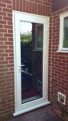 an open white door on a brick building