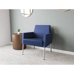 a blue chair sitting in front of a round mirror on a wall next to a plant