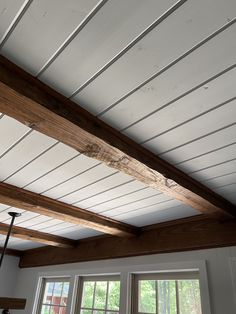 the ceiling in this kitchen is painted white and has exposed wood beams on it