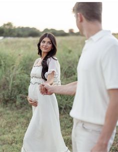 a pregnant woman holding the hand of her husband