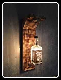 a light that is on the wall next to a wooden block with a bottle in it