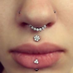 a woman's nose with three different piercings on her left side and two smaller ones in the middle