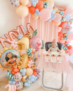 a baby sitting in a highchair with balloons and decorations around it that spell out the word happy