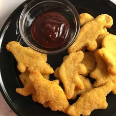 fried fish sticks with ketchup on a black plate