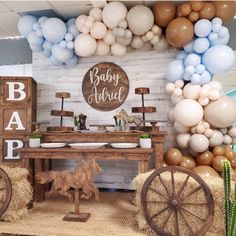 a baby shower is decorated with balloons, hay bales and farm animals for decoration