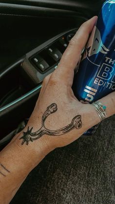 a person with a tattoo on their arm holding a can of energy drink in their hand