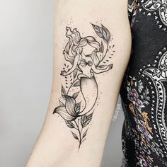 a woman's arm with a black and white tattoo on it