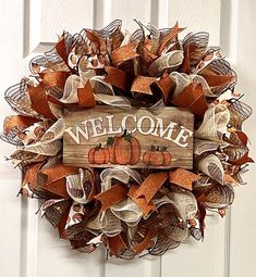 a welcome fall wreath with pumpkins and burlocks hanging on the front door