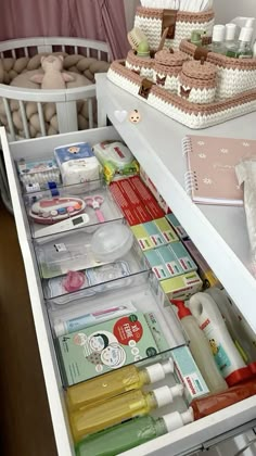 an open drawer in a white cabinet filled with cosmetics and personal care items on it