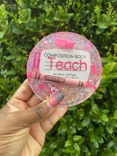 a person holding up a compact book with pink and silver sprinkles on it