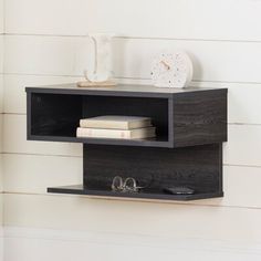 a shelf that has some books on top of it and glasses in front of it