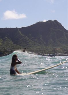 a woman riding a surfboard on top of a wave in the ocean