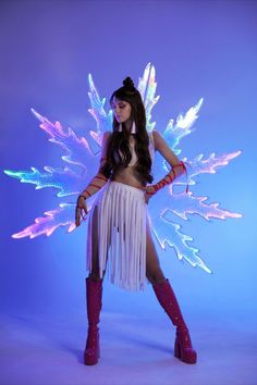 a woman dressed as a fairy standing in front of a blue background