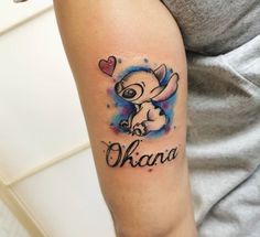 a woman with a tattoo on her arm that says okana and an elephant holding a heart