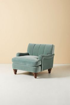 a blue chair sitting on top of a white floor next to a brown and tan wall