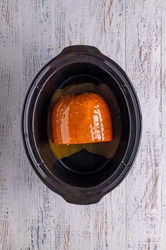 an overhead view of a food processor with sauce in it on a white wooden table