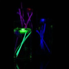 two glowing sticks in a glass filled with water