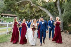 a bride and groom walking with their bridal party