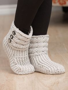 a close up of a person's feet wearing knitted boots