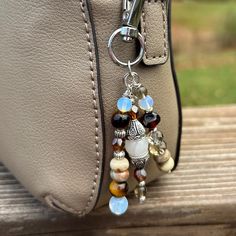 a handbag with charms hanging from it on a wooden bench