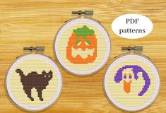 three cross stitch pumpkins with faces on them are shown in the hoop, and one is